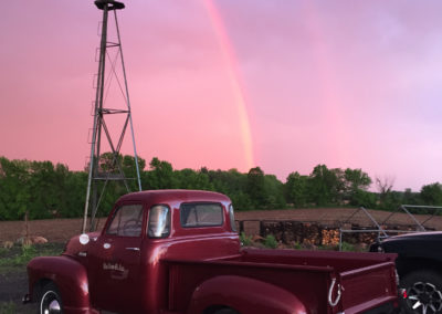 classic maroon truck with windmill and rainbow